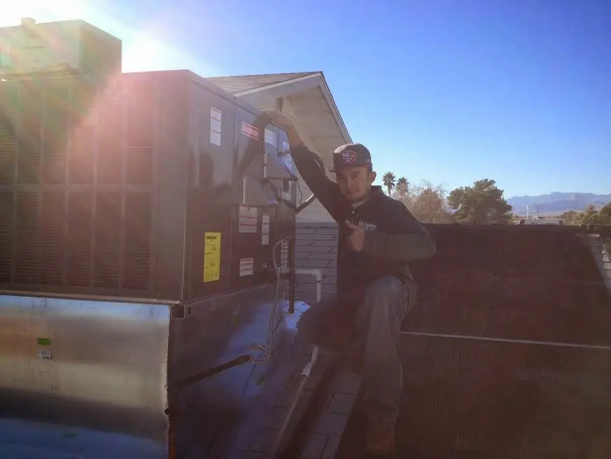 HVAC technician performing AC Tune-Up on a rooftop unit in Countryside